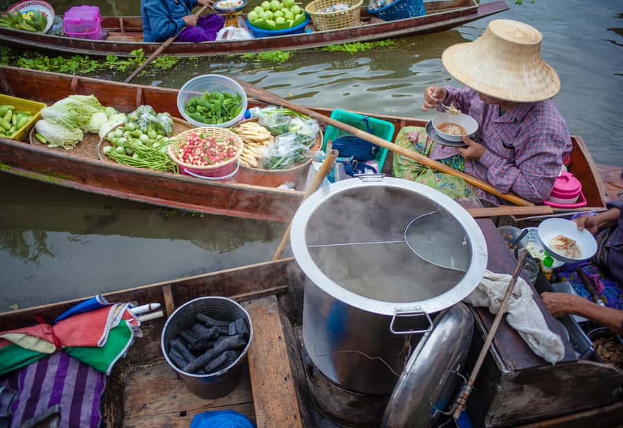 From Bangkok: Maeklong Railway and Floating Market Food Tour - Arriving at Damnoen Saduak by longtail boat